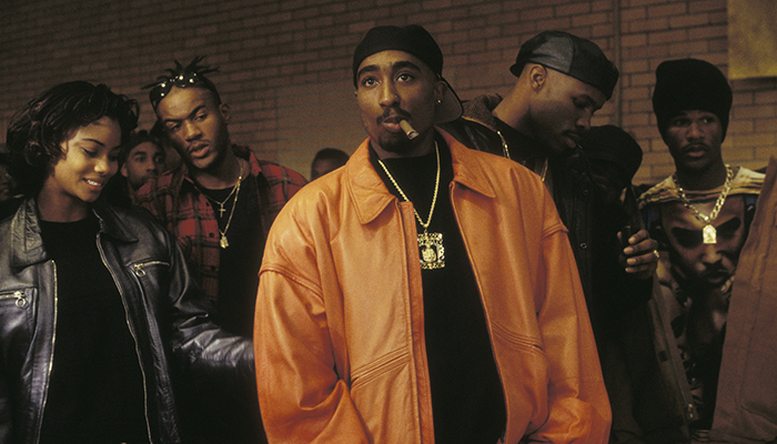 Image of Tupac as Birdie in Above the Rim, standing in a group of people.