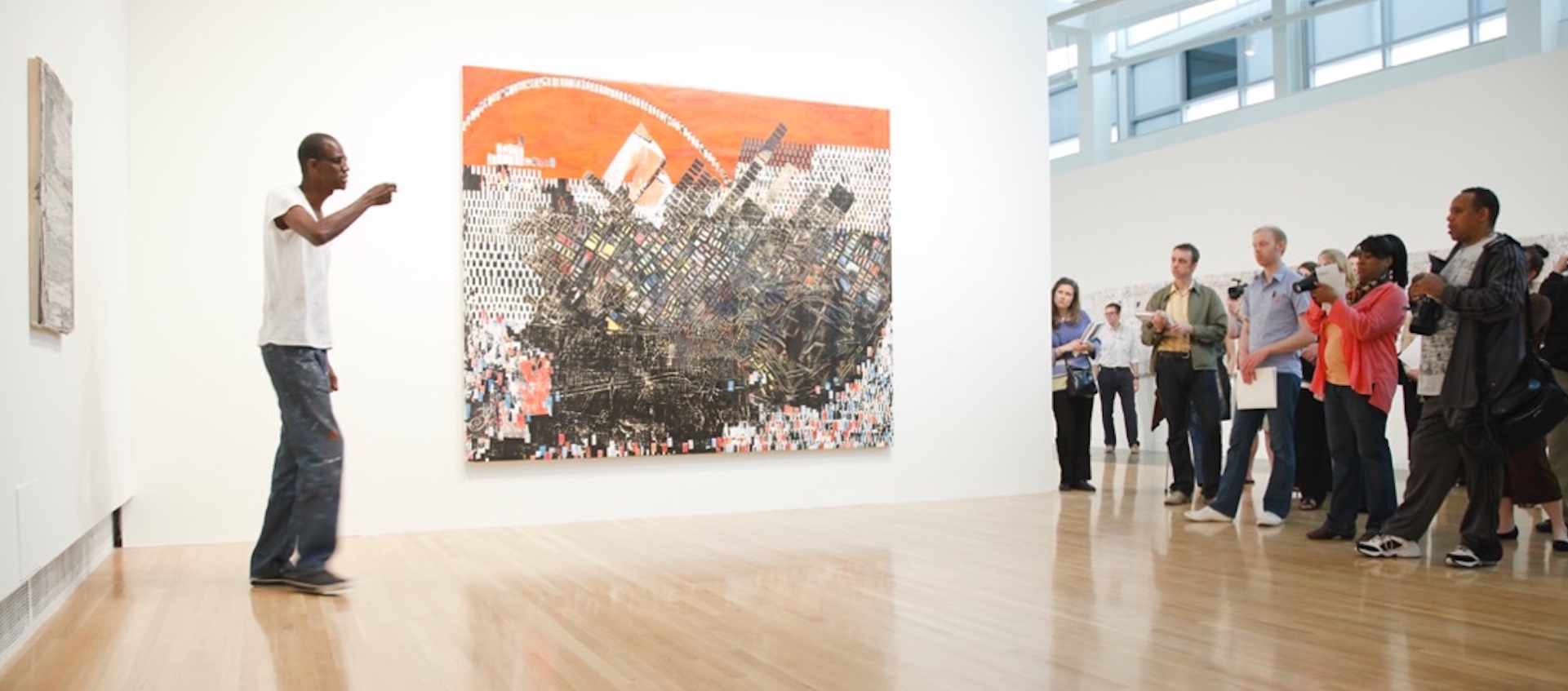 Artist Mark Bradford standing next to one of his paintings in the Wexner Center for the Arts galleries as he leads a tour through his 2010 solo exhibition 