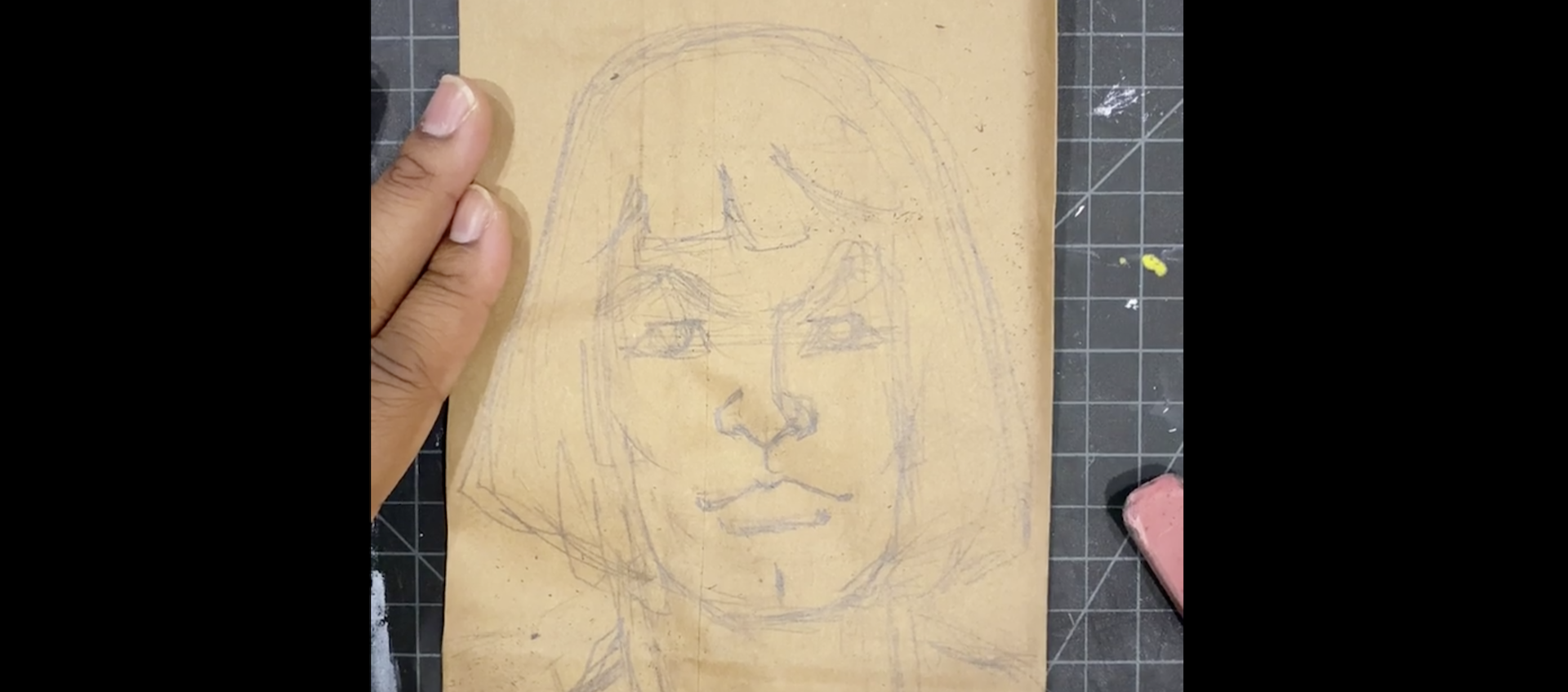 A pencil sketch of He-Man on a drawing board, held down on the left by two fingers of the artist, Alexander Chisley