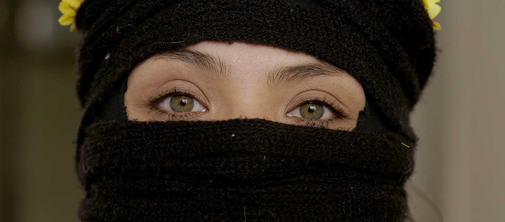 a person's face covered in black fabric except for the eyes