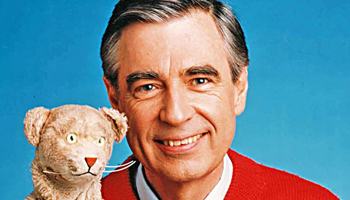 A headshot of Fred Rogers holding the puppet Daniel Tiger.