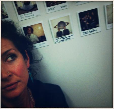 <p> Filmmaker Jeanne Liotta gazes at polaroids of past F/VSP residency artists </p>
