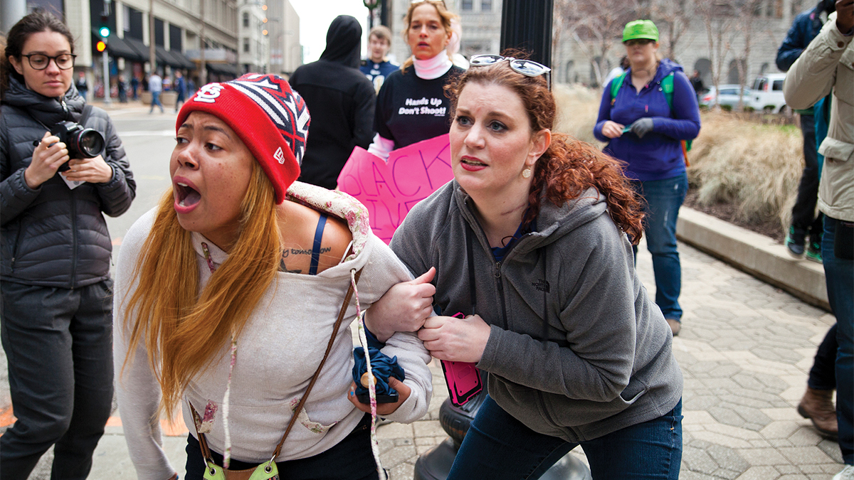 Film still of a woman yelling in distress while her friend holds her arm