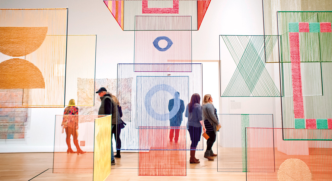 Large geometric textile shapes of different colors hanging from the ceiling the Wexner Center galleries