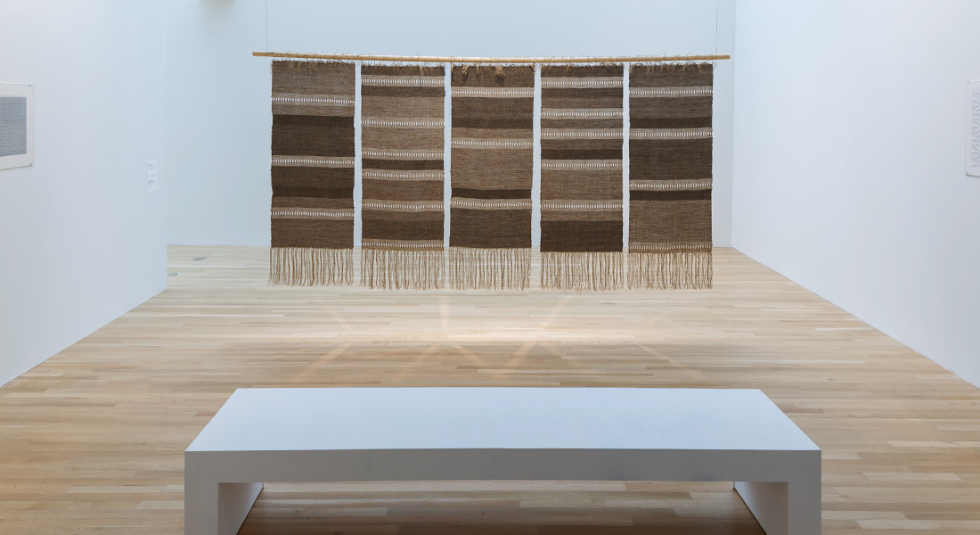 Installation view of weavings hanging from the ceiling