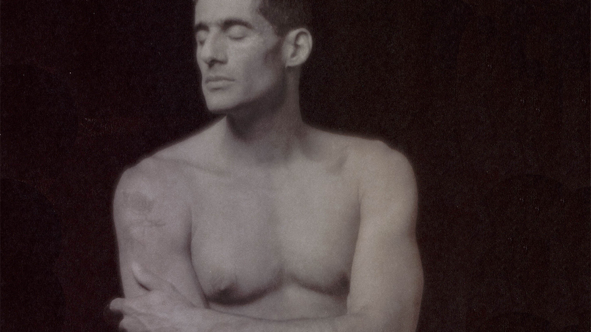 A shirtless man with his eyes closed.