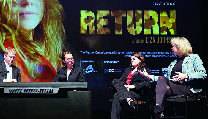 Five panelists on a stage in discussion