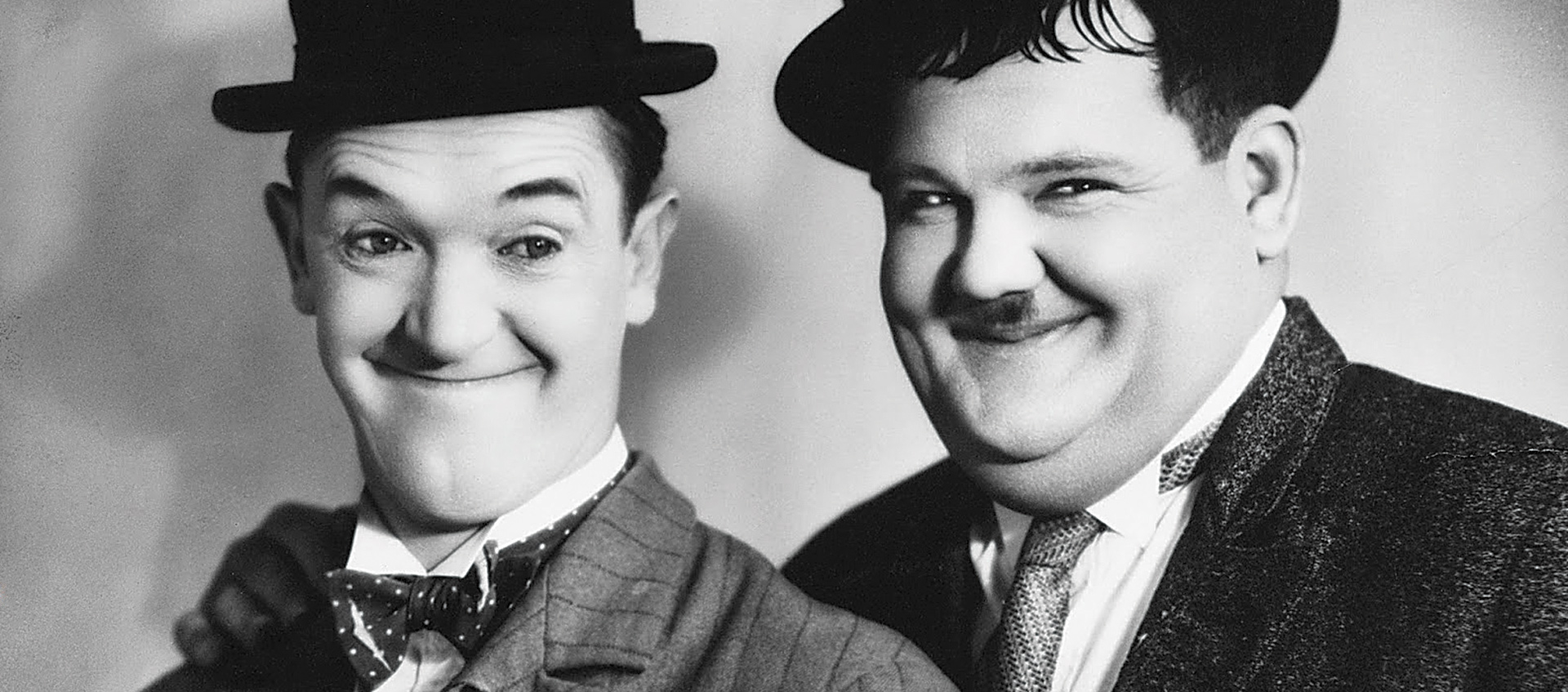 Two men in bowler hats smile for the camera