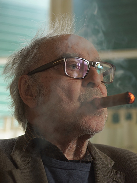 Older man in glasses smoking a cigar