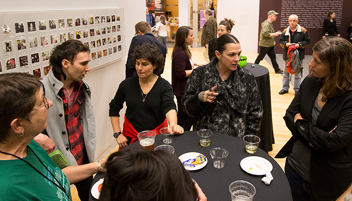 A group of people standing around a table at a Cinema Revival reception