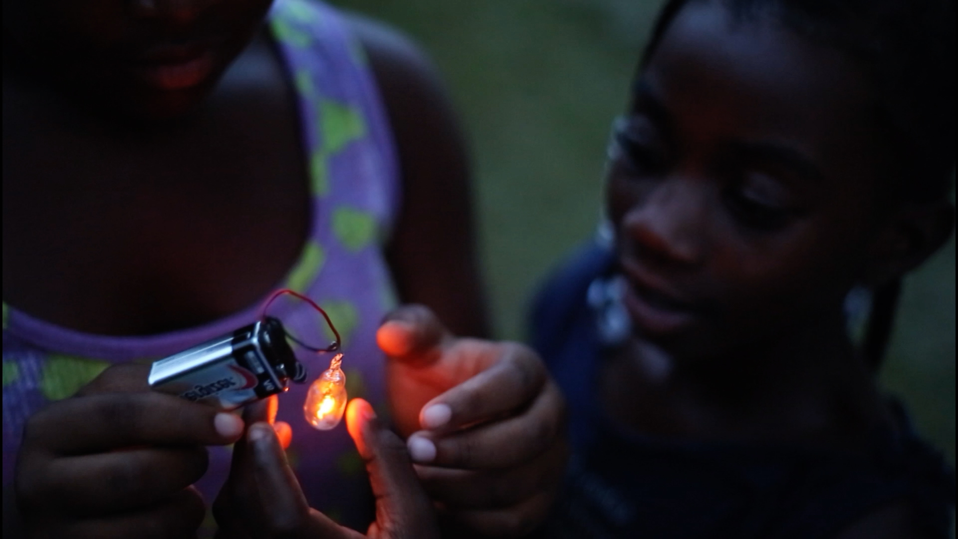 A still of two children powering a small light with a 9-volt battery from the 2018 documentary Hale County This Morning, This Evening by director RaMell Ross
