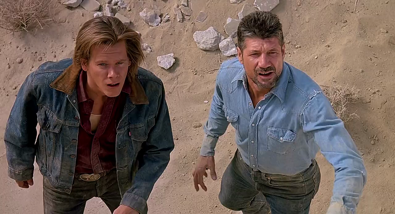 Actors Kevin Bacon and Fred Ward looking dazed in the desert in the 1990 scifi action film Tremors