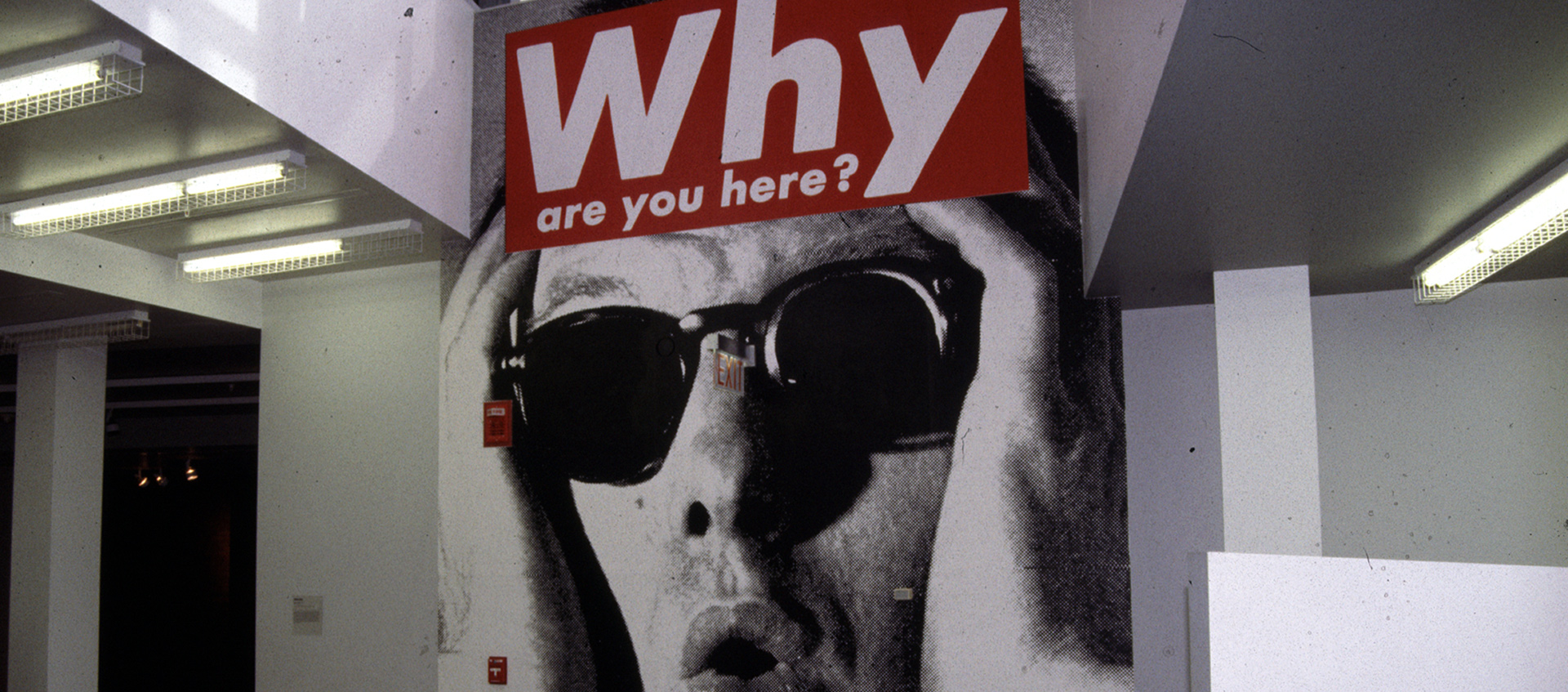 large mural of Barbara Kruger's work with the text: why are you here?