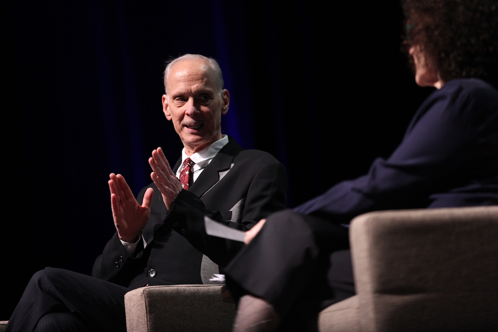 Filmmaker, artist, and author John Waters with writer Lynne Tillman on the stage of Mershon Auditorium during the March 18, 2019 Lambert Lecture at the Wexner Center for the Arts. Photo: Brooke LaValley