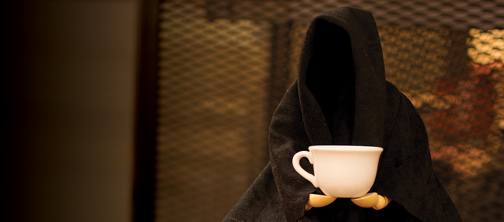 Death holding coffee cup