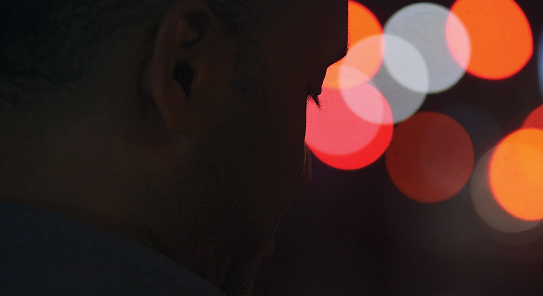 Person looking pensive with light flares in background