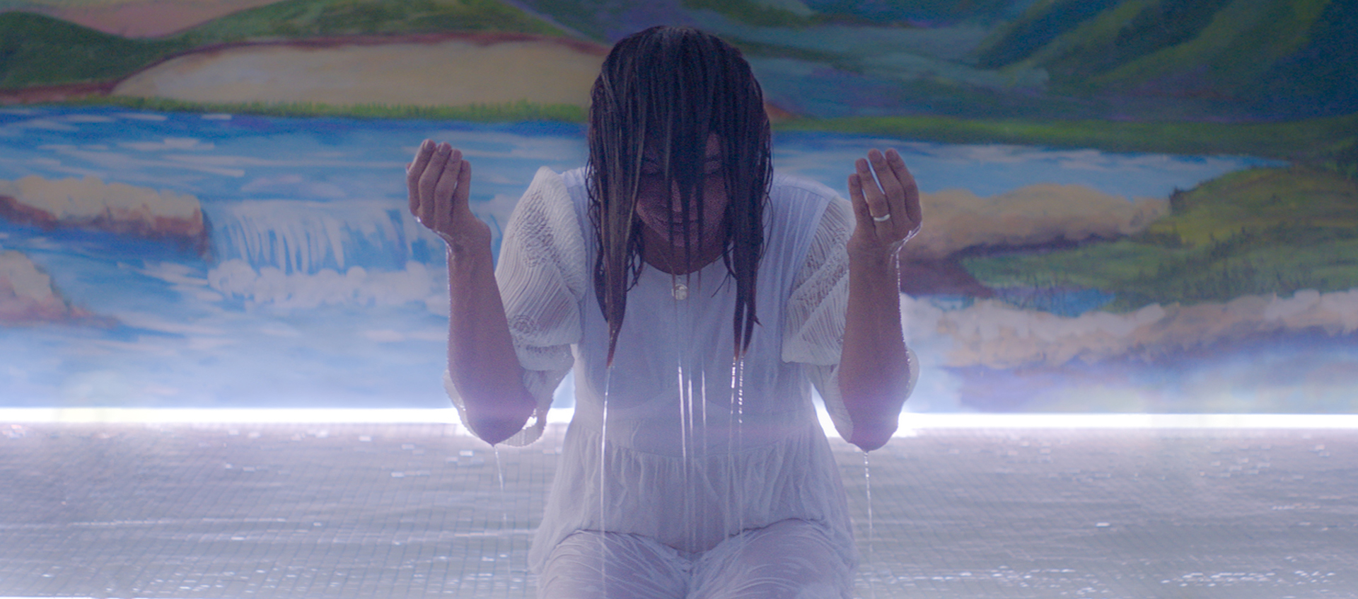 A promotional still from Gabriel Mascaro's film Divine Love of a soaked woman bowed in prayer in a body of water