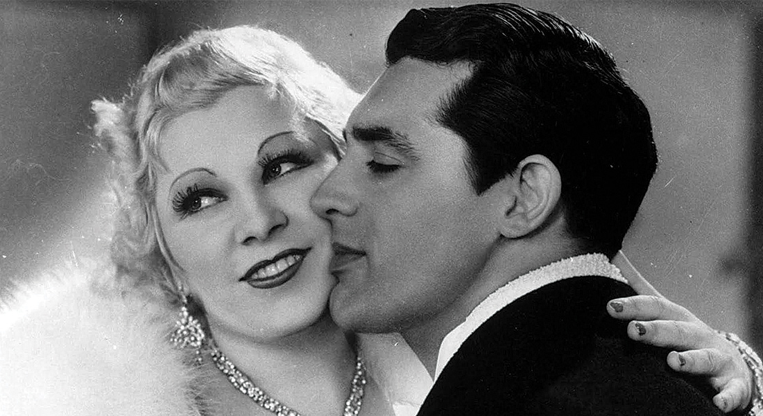 Cary Grant kisses Mae West's cheek in a still from the 1933 film I'm No Angel