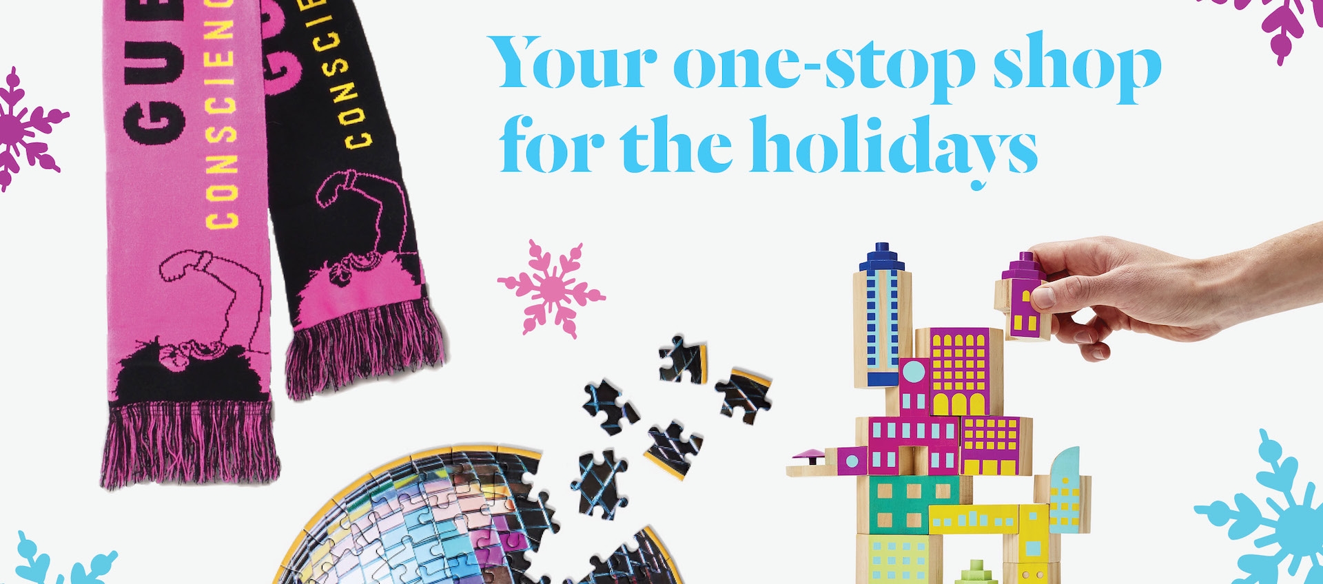 A pink and black knit Guerilla Girls scarf, a jigsaw puzzle and a building block set against a white background marked with pink and blue snowflakes and the phrase "your one-stop shop for the holidays"