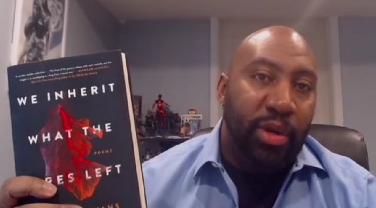 Author William Evans holding up a copy of his new book We Inherit What the Fires Left