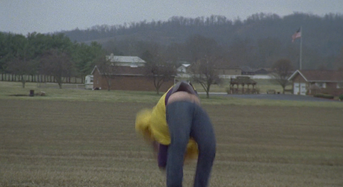 A person doing a back flip in a field.