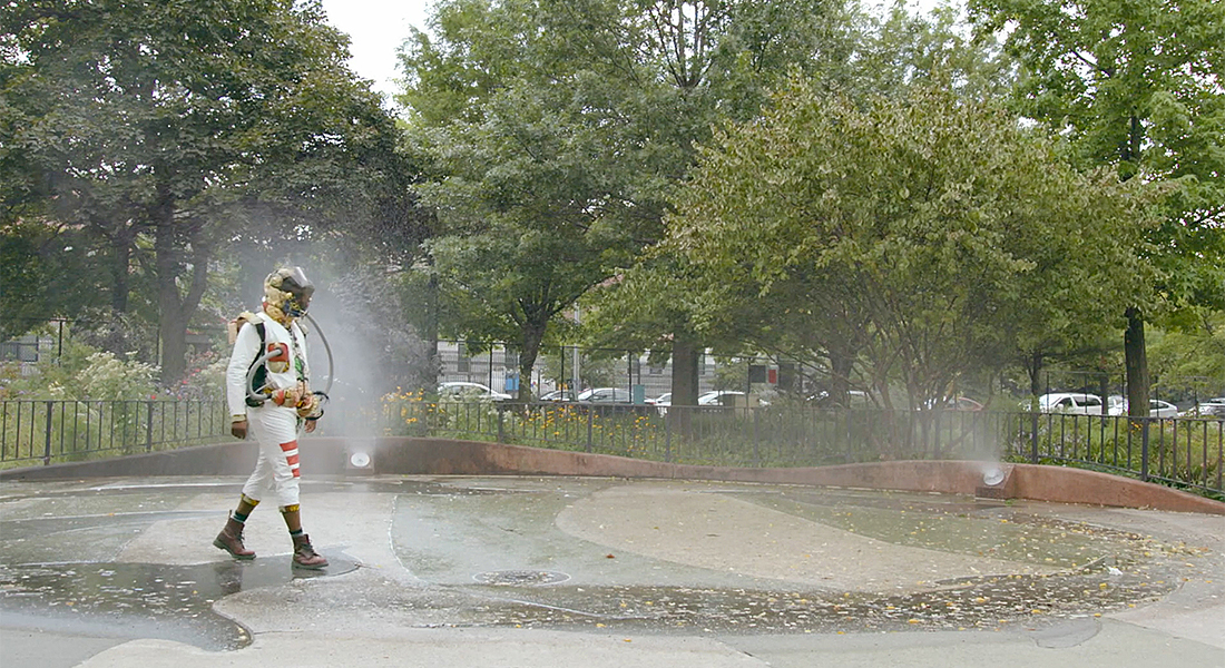 a person in an astronaut costume walked in a misty park 