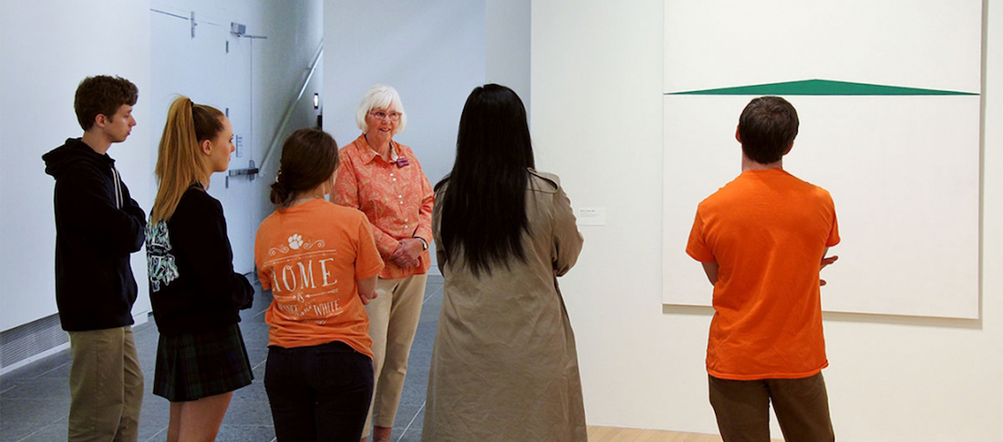 A Wexner Center volunteer docent leads patrons through an exhibition of paintings by Carmen Herrera