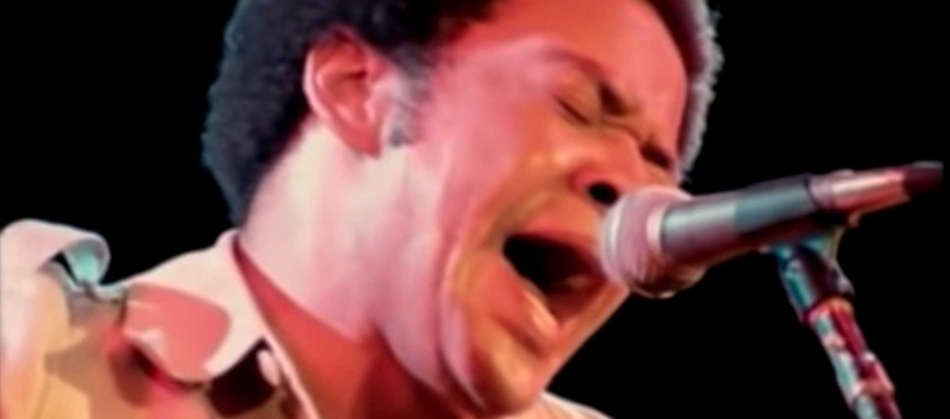 Musician Bill Withers sings into a microphone in a scene from the documentary Soul Power