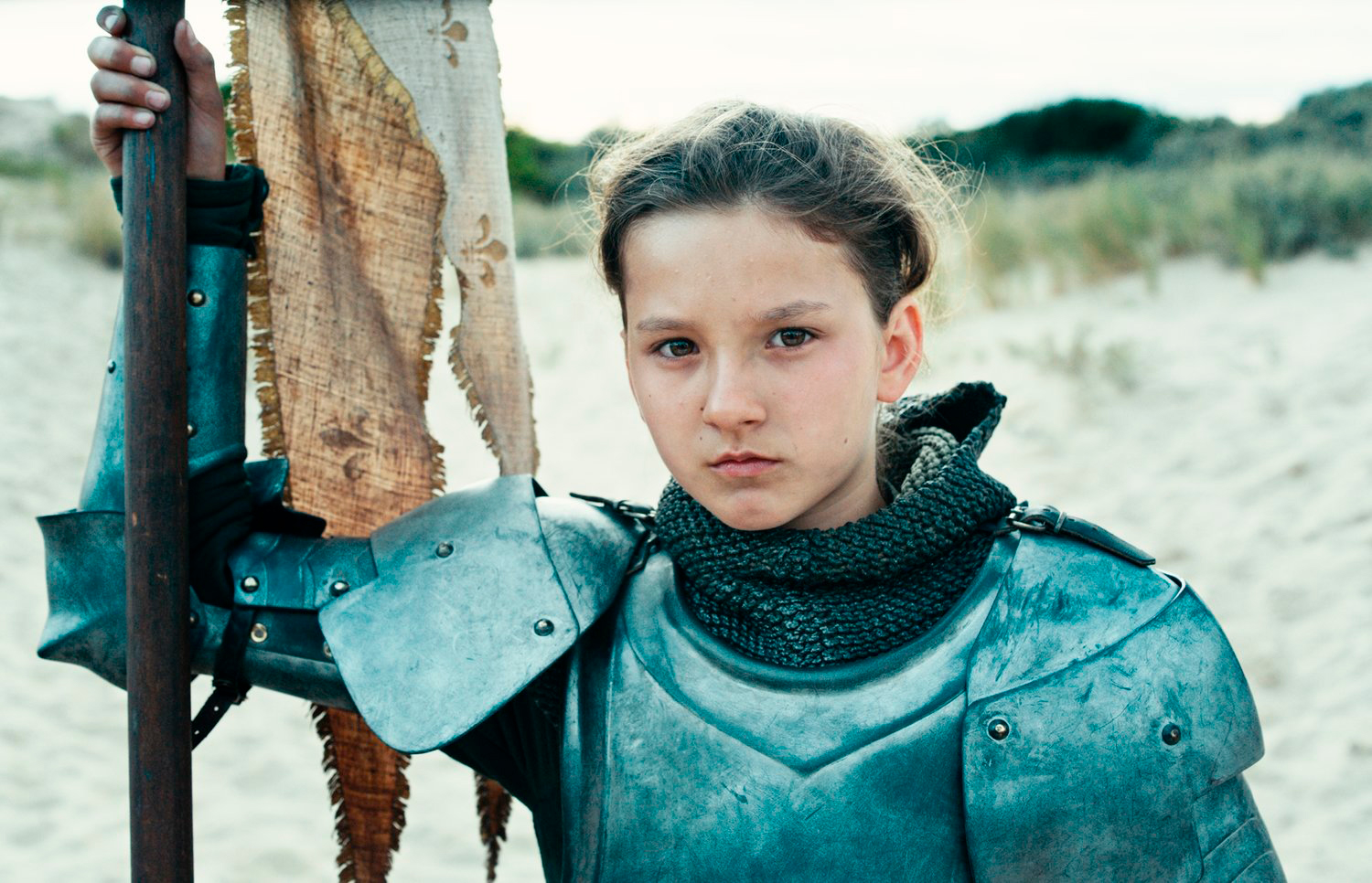  Lisa Leplat Prudhomme as Joan of Arc in knight's armor holding a flag pole on her with her right hand