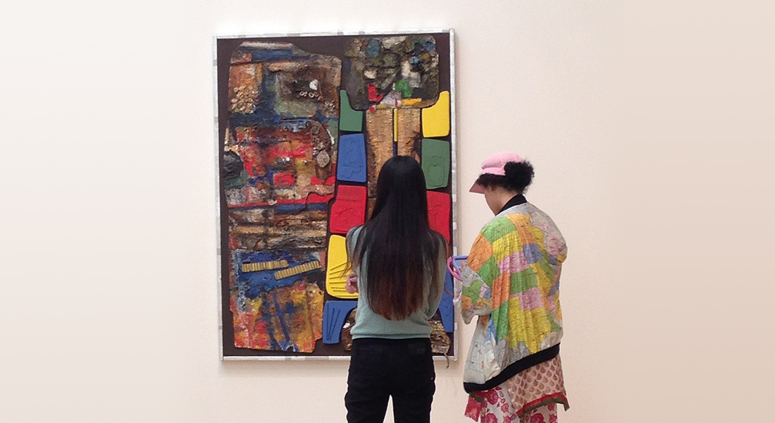 Students look at a painting by Noah Purifoy in our galleries
