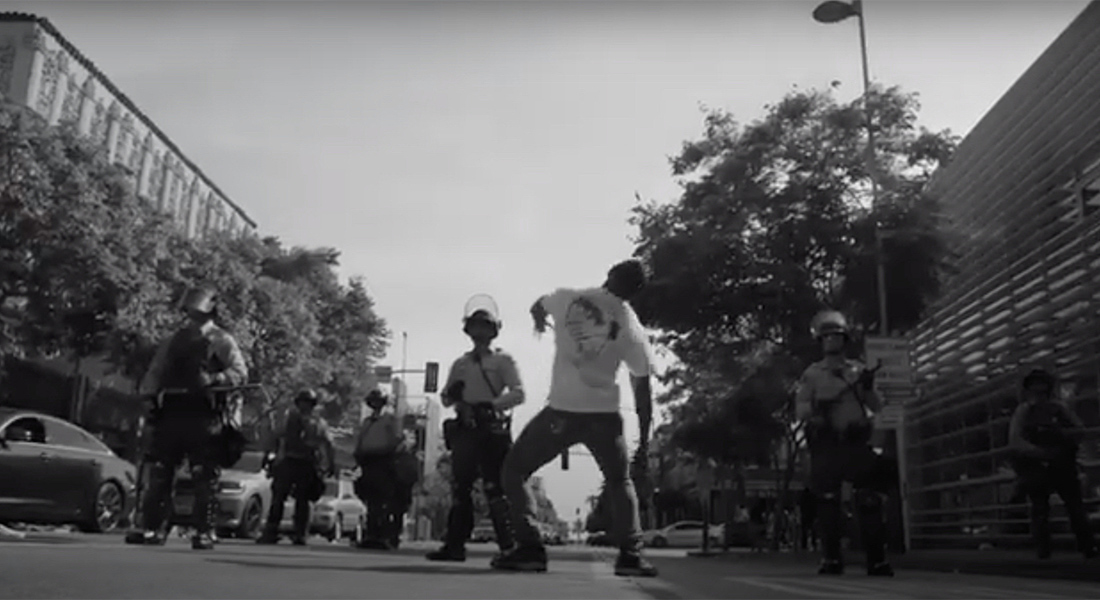 Los Angeles Krumping founder Jo'Artis Ratti dances in front of a line of police in riot gear during the George Floyd protests