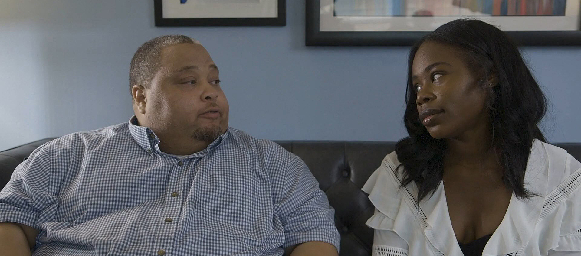 Image of a black man and woman sitting on a couch from from the short film We Fight We Love by Michael Artis