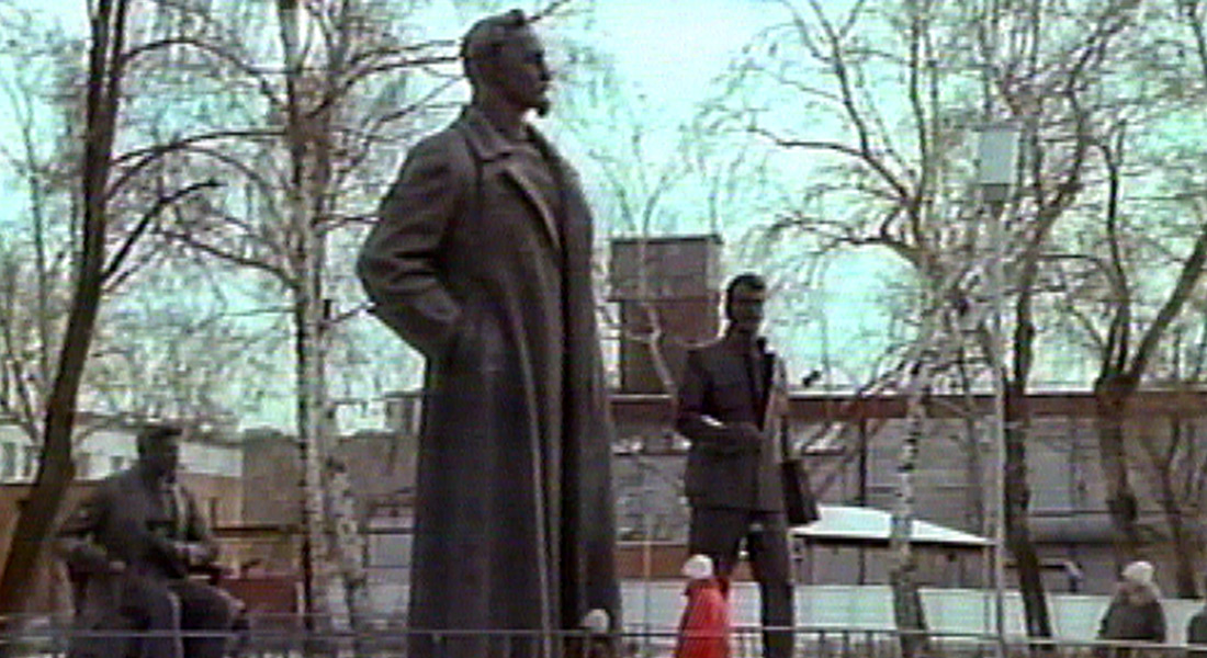 People walk by monumental Soviet statues in an outdoor park