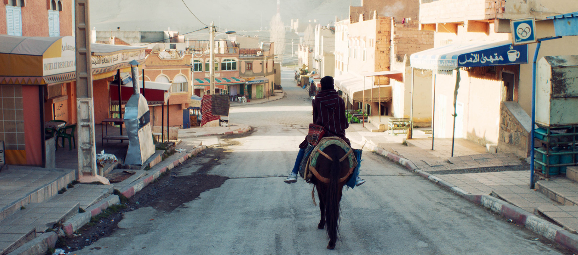 A horse and rider move down a city street in the short film So What If the Goats Die