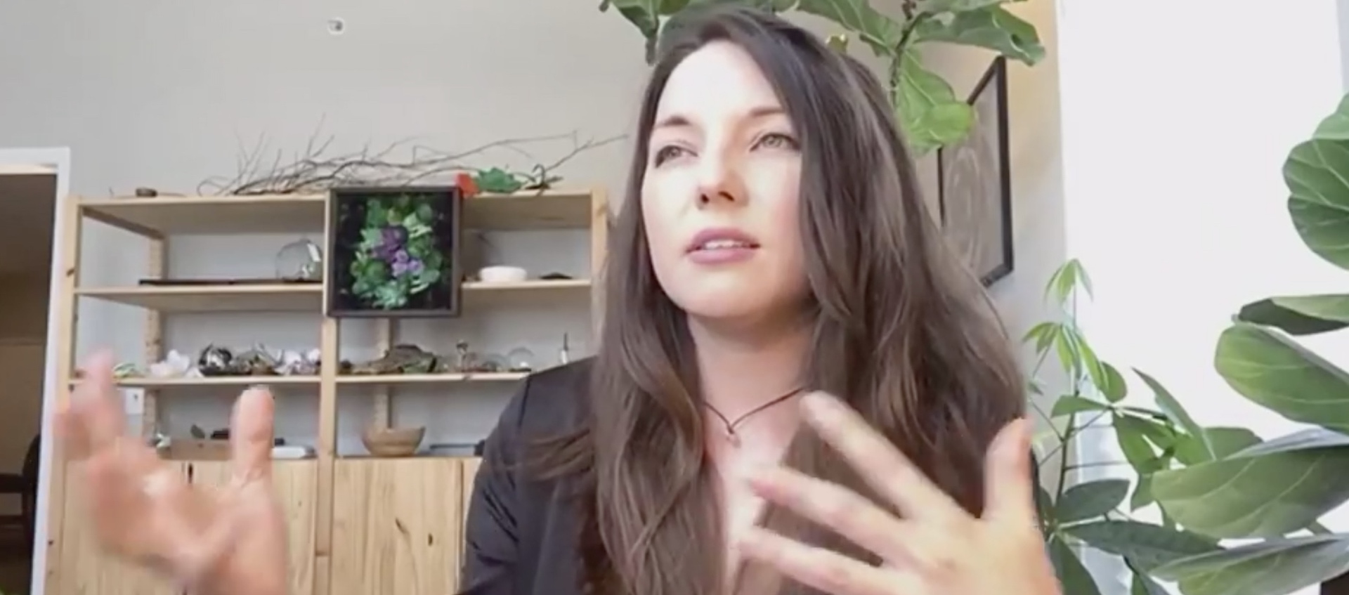 Columbus paper artist Lea Gray sits in her studio gesturing with her hands as she discusses her work in a livestream conversation