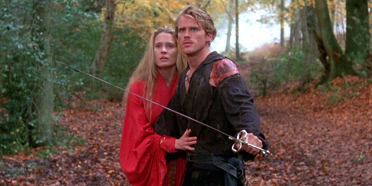 Robin Wright's Princess Buttercup and Cary Elwes' Wesley (Dread Pirate Roberts) hold each other close on the edge of the fire swamp as he brandishes a sword at enemies off camera in a scene from the film The Princess Bride