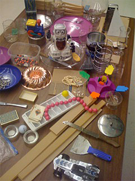 A table full of everyday materials including a cake mold, plastic beads, and a paint scraper. All were used by animator Amy Yoes for her stop motion film Equator