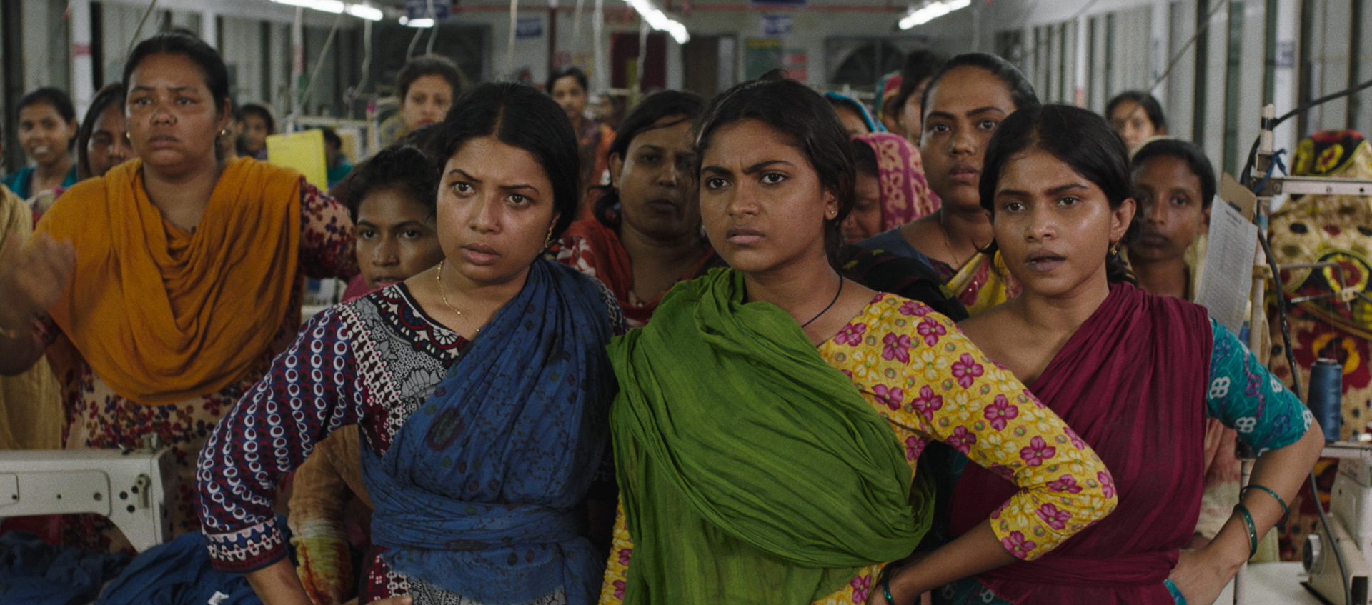 A group of Bangladeshi women stare intently at something off screen in the film Made in Bangladesh