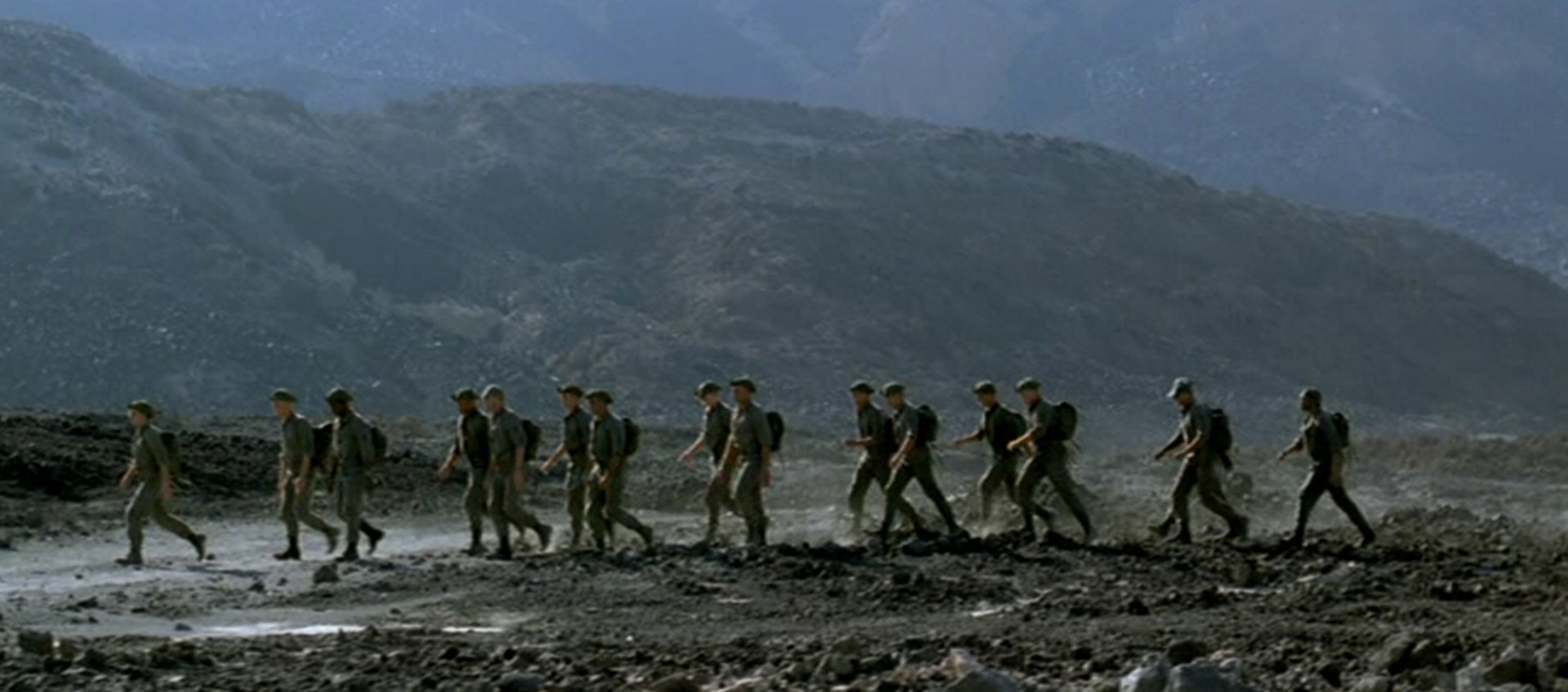 A group of soldiers march on a hillside