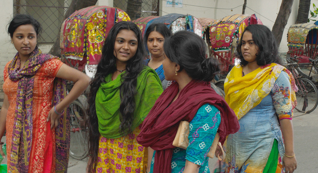 A group of women in saris talk while walking together