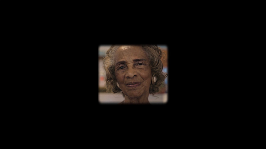 A close up of an old woman's face framed by a blank black background