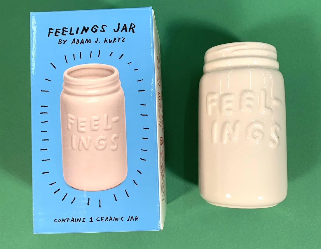 A white ceramic jar bearing the word "feelings" with the box the jar comes in