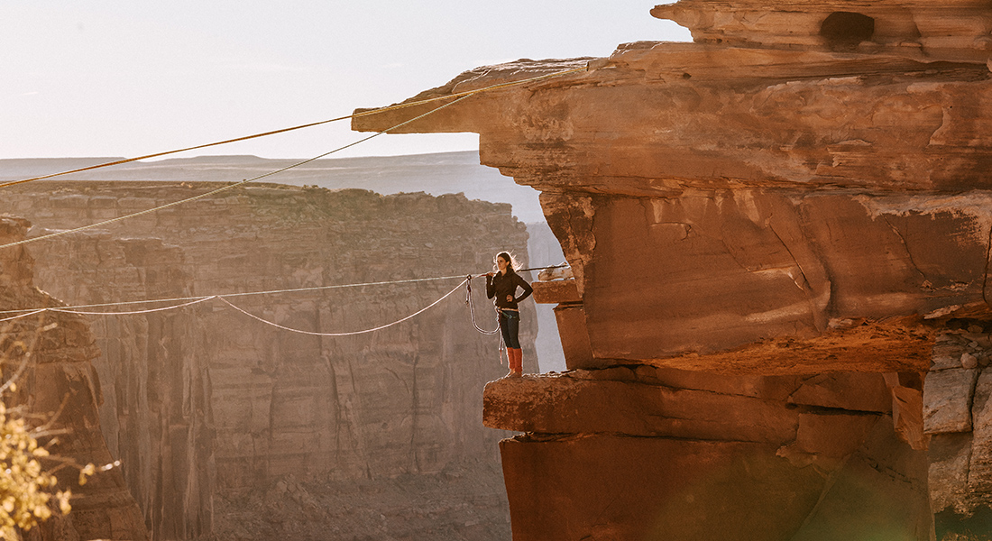 A woman looks out at a rope hanging in the canyon.