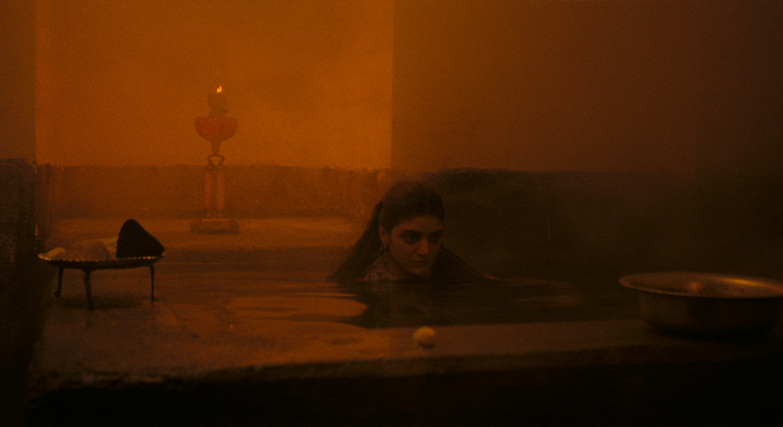 An orange tinted image of a woman emerging from a pool