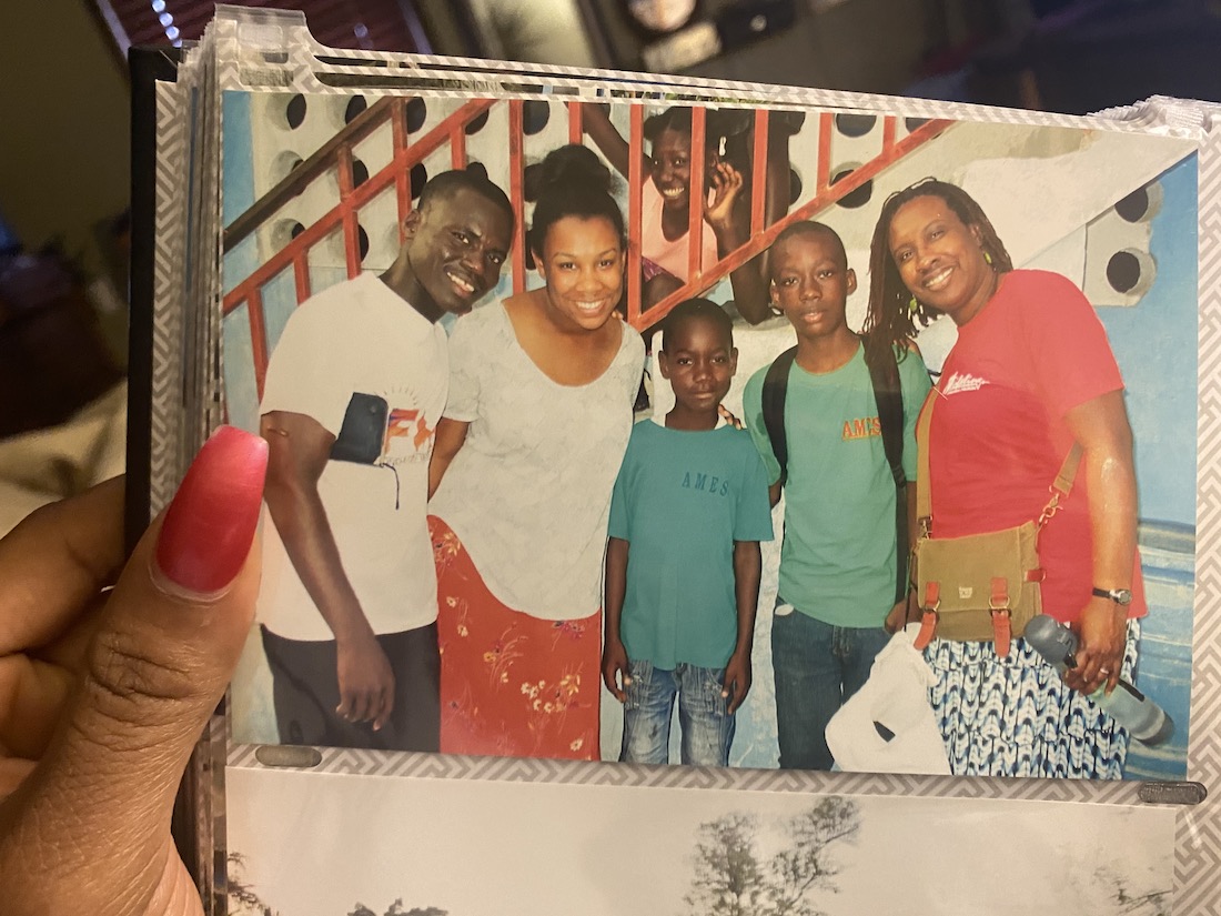 Wexner Center for the Arts intern Simone Robinson's hand holding a photo of her and her mother posing with three friends in Haiti