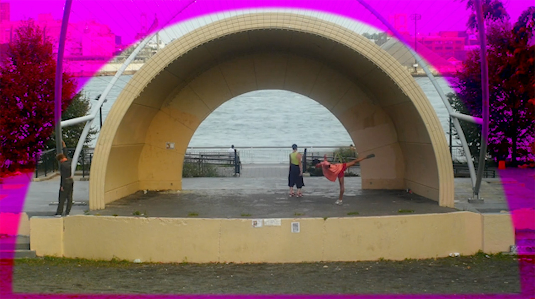 A screenshot of dancers performing in an archway. A pink radiating graphic is overlaid on top of the image.