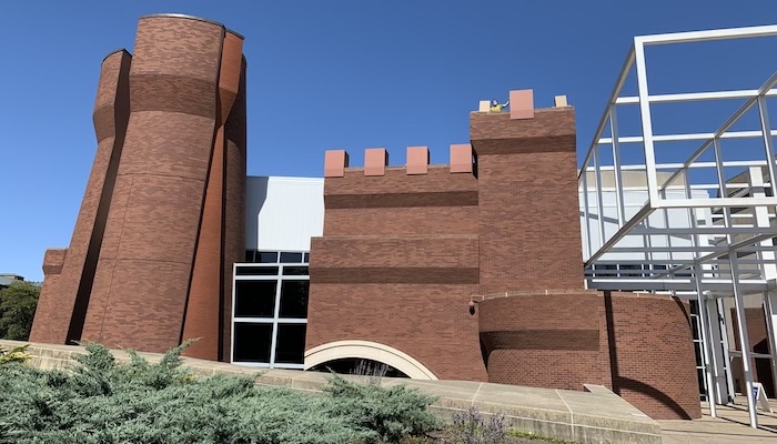 A wide view of the re-installation of Chris Burden's Wexner Castle onto the exterior of the Wexner Center for the Arts; preparator James-David Mericle can be seen working on the installation