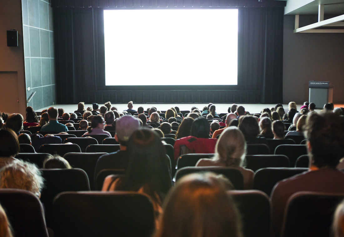 Darkened Wexner Center Film/Video Theater with solid white light projected on the screen