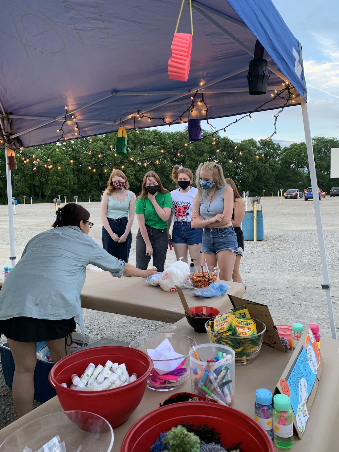 Four teenage girls in face masks approach the staff table at South Drive-In
