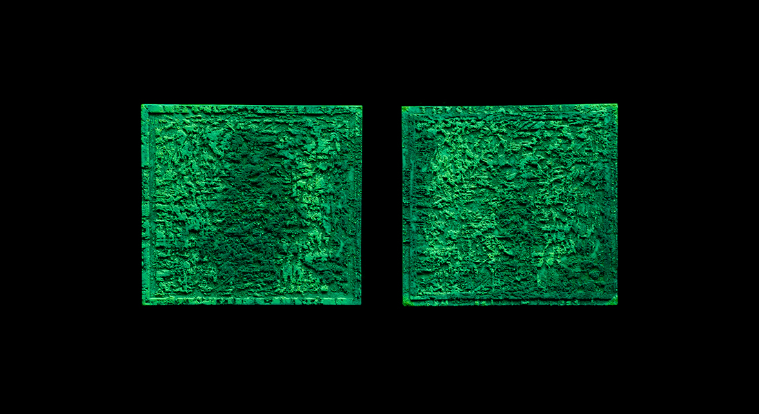 Two green canvases with mottled looking surfaces hang side by side in the Wexner Center's galleries lit only with ultraviolet light
